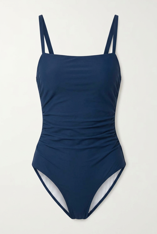 Navy blue swimsuit with thin straps on a light gray background