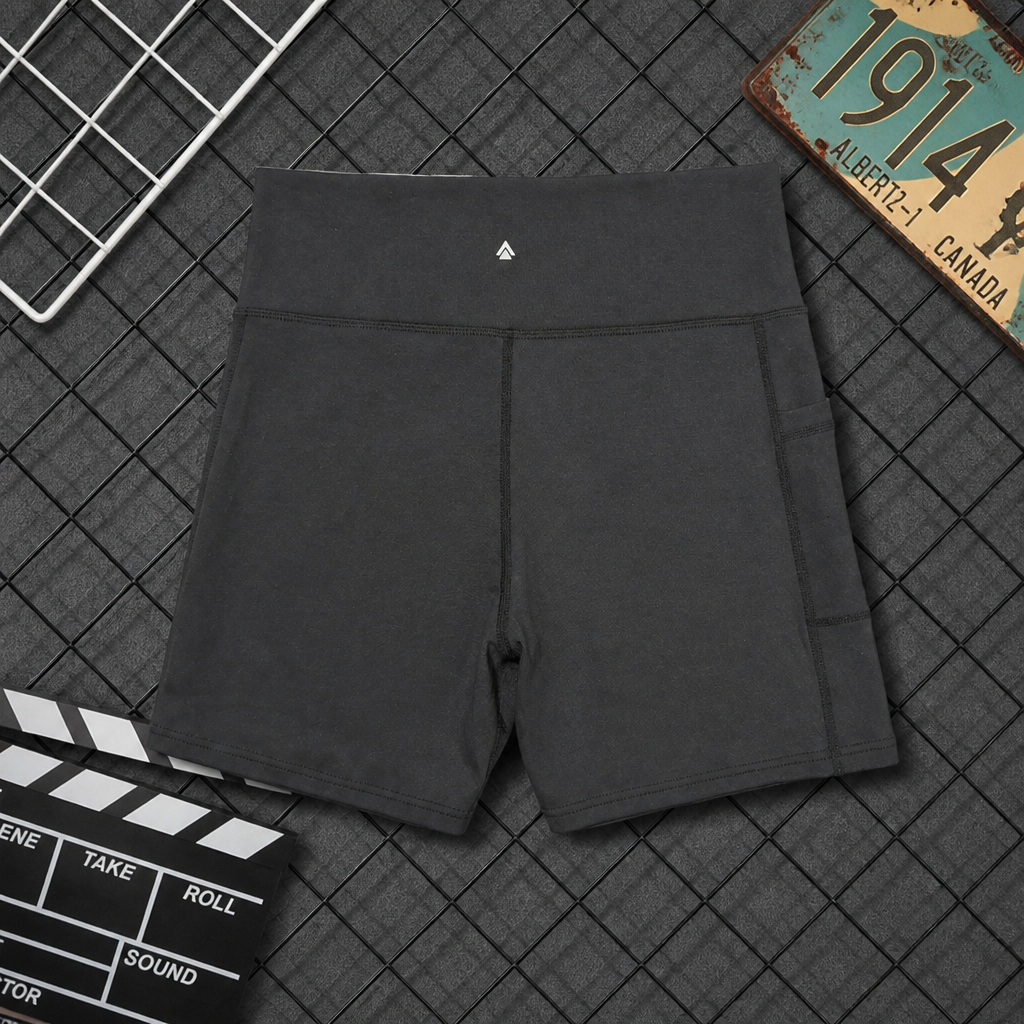 Black shorts on a textured surface with a clapperboard and vintage license plate.