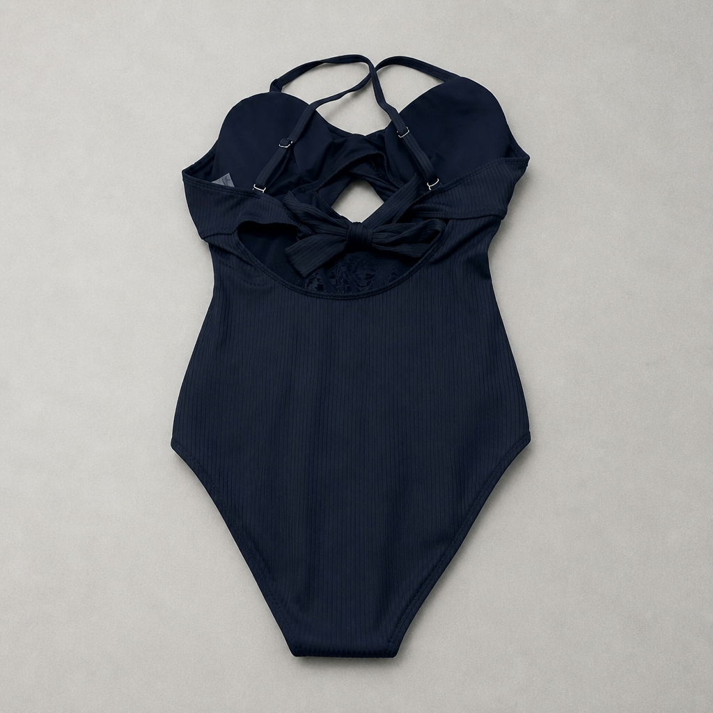 Navy blue swimsuit with ruffled neckline on a light gray background