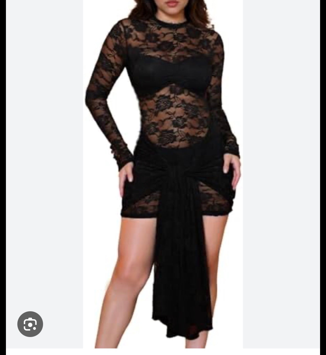 A woman modeling a black sheer lace long-sleeve mini dress with a ruched front and asymmetrical hem, shown against a plain light background.