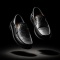 Pair of black leather loafers on a black background