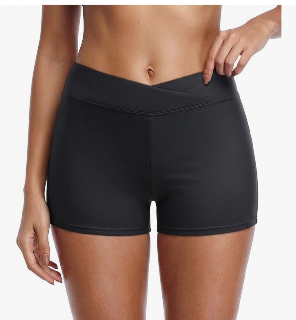 Black athletic shorts worn by a person on a white background