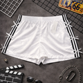 White shorts with black stripes on a dark surface with film-related props.