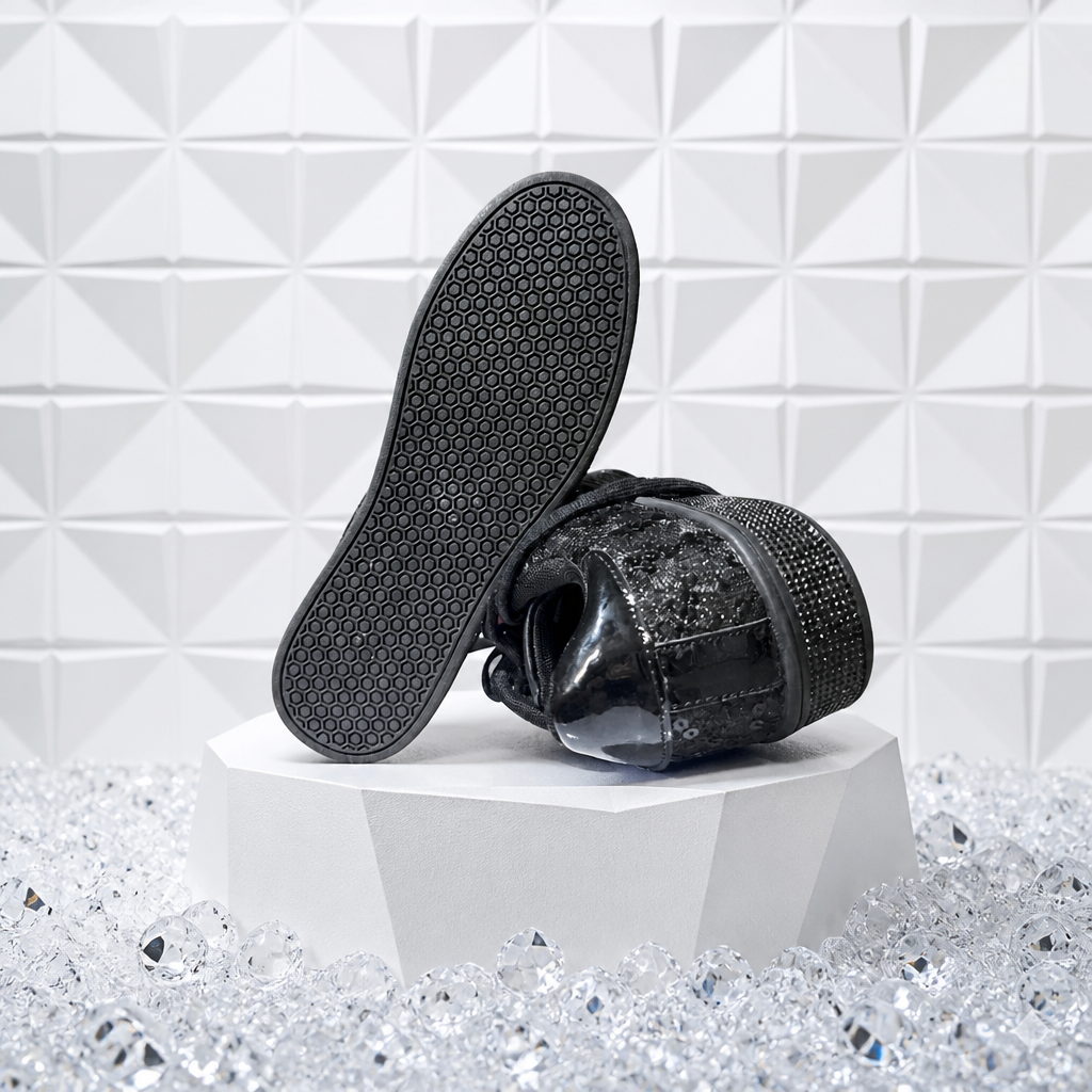 Black shoe with rhinestone embellishments on a white geometric patterned background