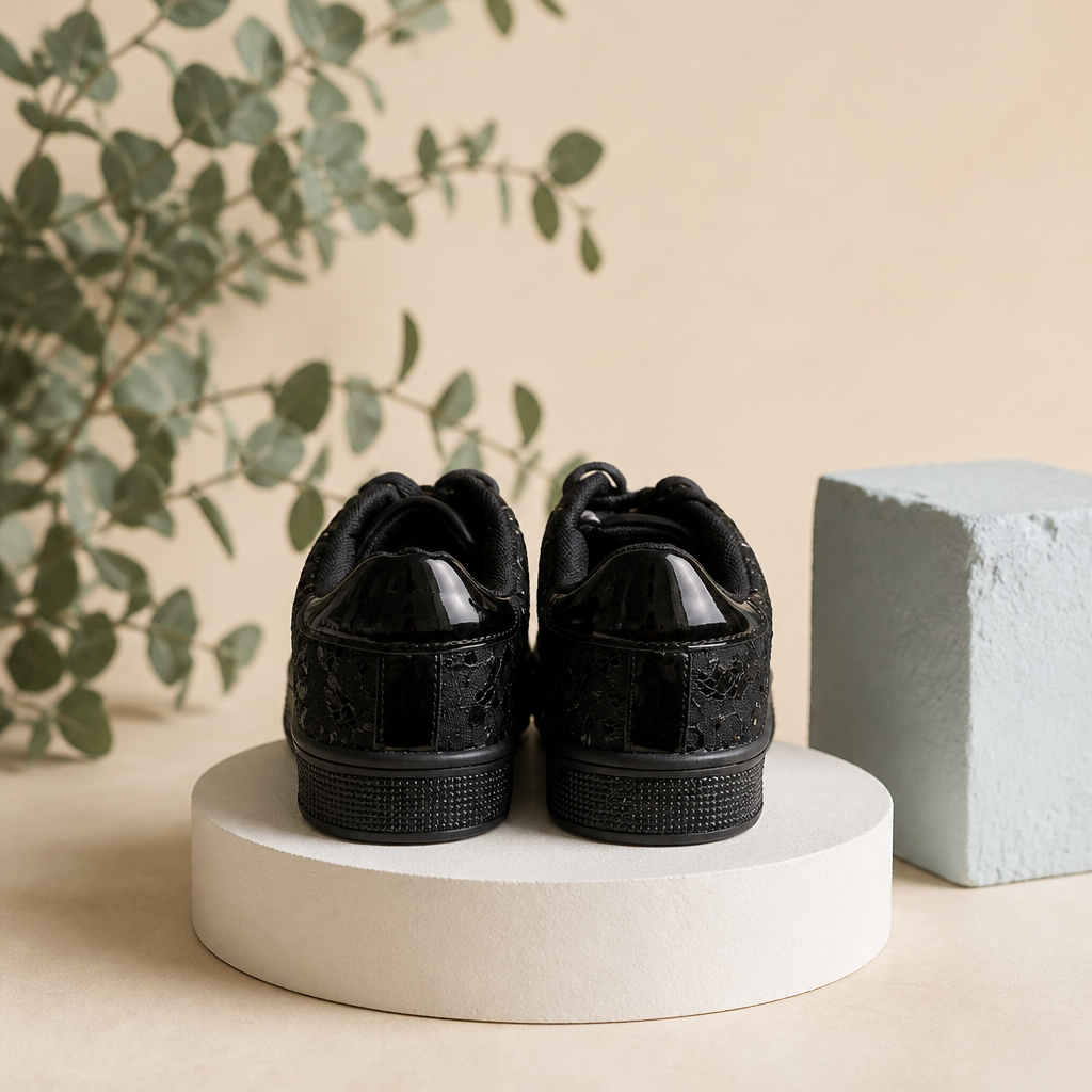 Pair of black sneakers on a white pedestal with a natural background
